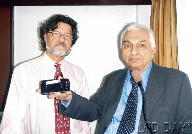 Dr Dariusz Leszczynski (L) and Prakash Munshi pose with the mobile sticker to encourage responsible use of cell phones. Pic/Suresh KK