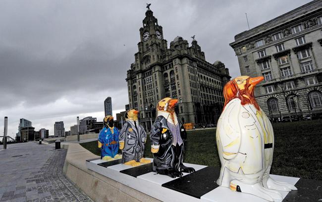 Fibreglass penguin caricatures of the Beatles in their famous Abbey Road crosswalk pose, stand on the pier head in Liverpool, located in North-west England on November 23, 2009. The Beatles’ penguins are part of a public art exhibition called Go Penguins, which saw  235 fibreglass penguins decorated by artists, celebrities and community groups as a finale to Liverpool’s year of the environment.