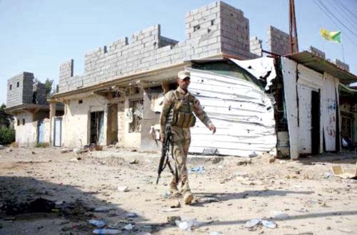 An Iraqi soldier walks through Jurf al-Sakhr after regime forces retook the town from Islamic State militants on October 27, 2014. File pic
