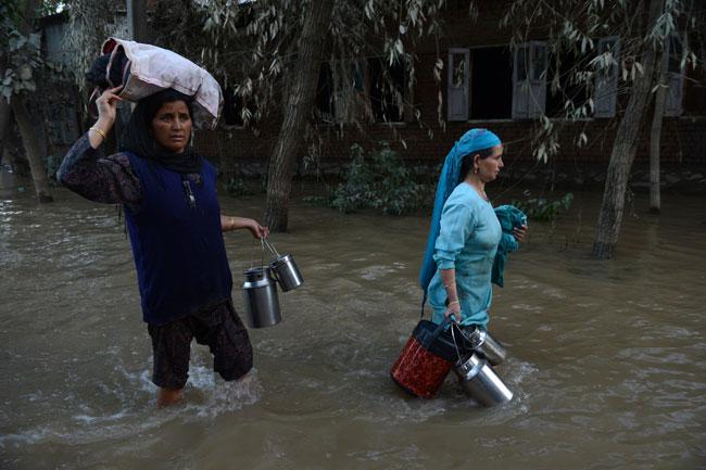 Kashmiri residents wade through floodwaters in south Srinagar