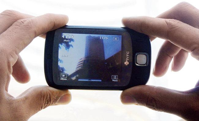 A tourist clicks a picture of the Bombay Stock Exchange (BSE) on his mobile phone. Pic/Bipin Kokate