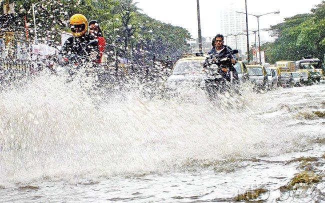 Heavy waterlogging in Parel meant that devotees had to wade through water to reach popular mandals. Pic/Rane Ashish