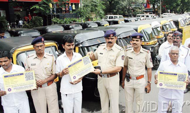 Traffic police officials and auto drivers display dummies of the smart identity cards that were installed yesterday. Pic/Sameer Markande
