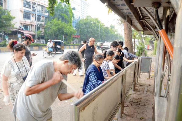 Participants clean the bus stop at Oshiwara during the clean-up drive initiated by Rakesh Bakshi and Lalit Vashishta
