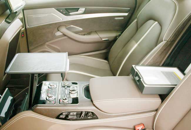 The central armrest on the backseat features a pop-out tray table