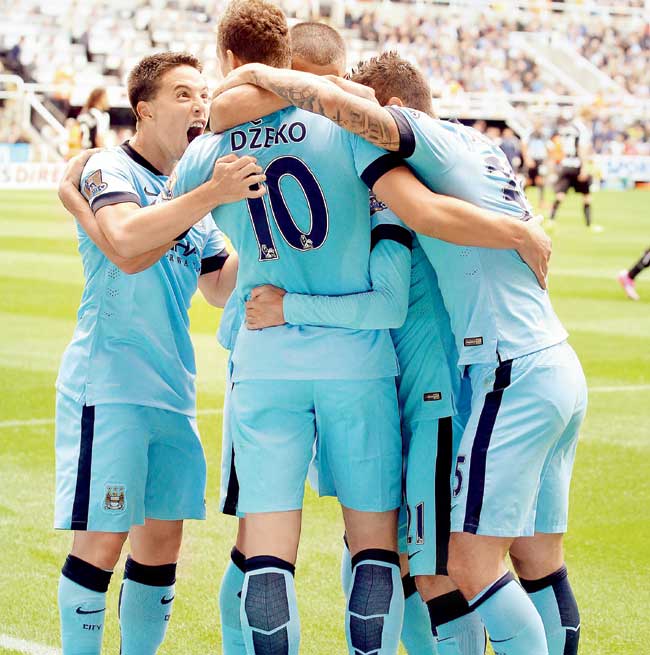 Manchester City players celebrate their opening goal against Newcastle United at St James
