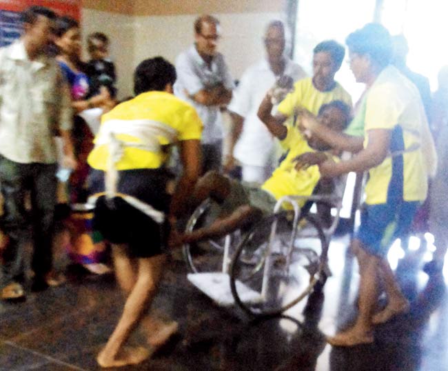team members wheel Jitendra Jagtap into Shatabdi Hospital 