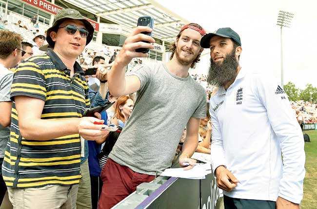 Moeen Ali poses for a selfie with a fan after England