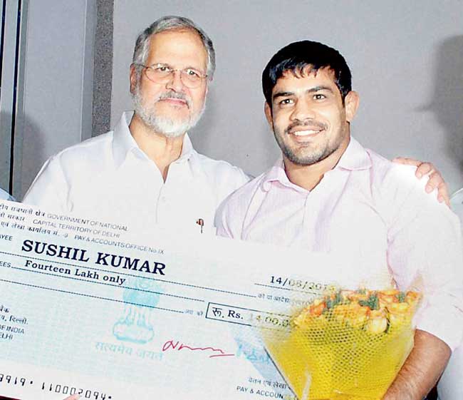 Lt Governor Najeeb Jung (left) felicitates wrestler Sushil Kumar in New Delhi yesterday. Pic/PTI