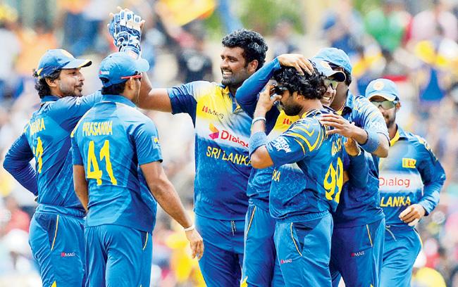 Sri Lanka pacer Thisara Perera (centre) celebrates with teammates the wicket of Umar Akmal on Saturday. He finished with 4-34. Pic/AFP