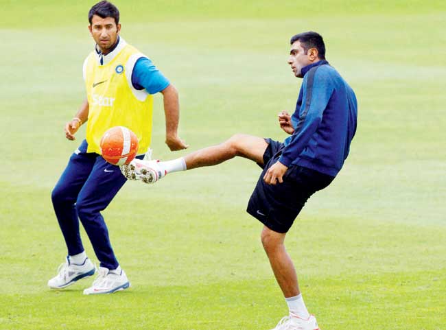 Cheteshwar Pujara (left) vies for the ball against R Ashwin during Team India