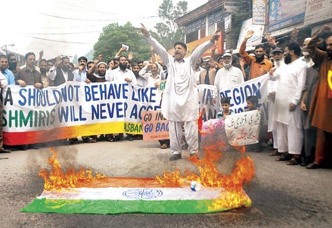 Kashmiri refugees chant slogans beside a burning an Indian flag during a protest against the visit of Narendra Modi to Kashmir as they strongly condemn his anti-Pakistan remarks, in Muzaffarabad, the capital of Pakistan-occupied Kashmir (PoK).  Pics/AFP