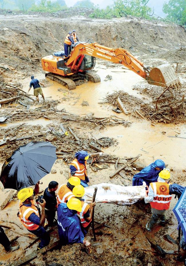 National Disaster Response Force personnel recover the body of a landslide victim amid heavy rain at the site in Malin village in Pune district. Pic/AFP