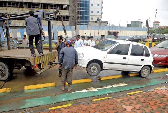 Traffic department tows away vehicles parked illegally on the roads. But drivers mostly sit inside the cars, and on spotting the towing van, move away. They then return later to claim the spot illegally again. File pic