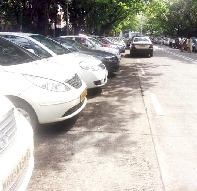 Vehicles are parked illegally on the road, since office-goers find the open parking lots full and the multi-level parking expensive