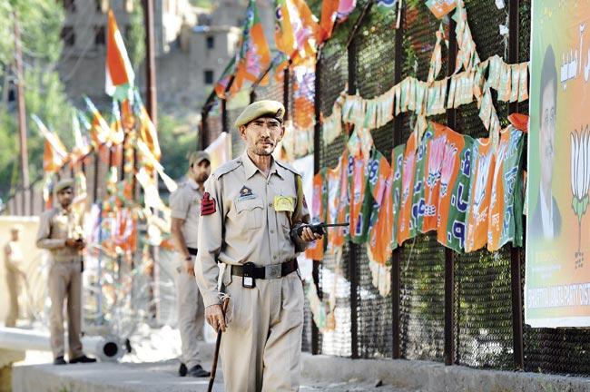 Policemen inspect the site of a public rally ahead of a visit by Narendra Modi in Kargil