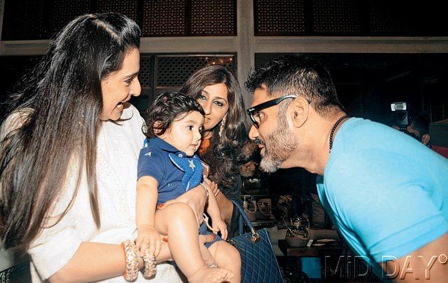 Suniel Shetty and wife Mana play with a child present at the event