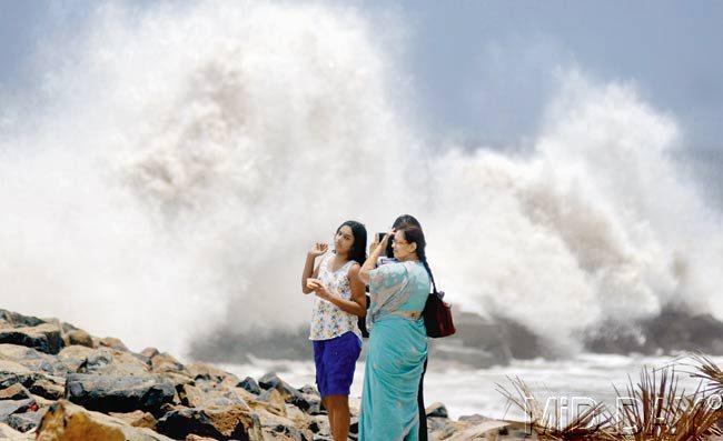 CLICK CRASH: Women take pictures as the high tide lashes Bandra Bandstand. Pic/Rane Ashish
