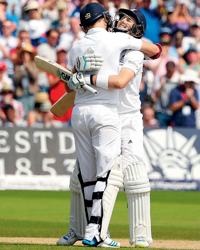 Joe Root (right) celebrates his century with James Anderson on Day Four of the first Test on Saturday. Pic/AFP