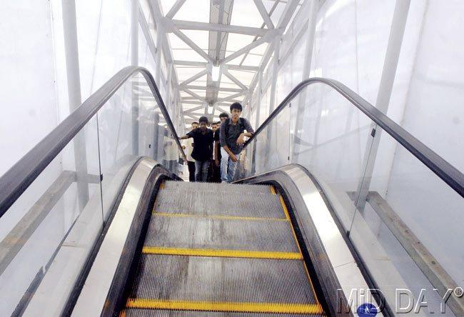 Both escalators had stopped working on Friday, and people are seen taking shelter on the Grant Road skywalk. Pics/Pradeep Dhivar