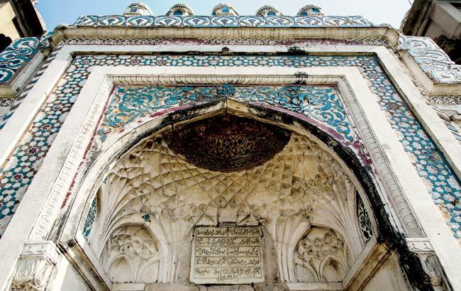 Cobalt and turquoise-coloured tiles on the arched doorways of Lal Khan’s tomb