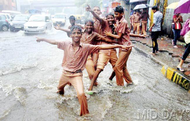 Schoolchildren making the most of the rains. Pic/Nimesh Dave