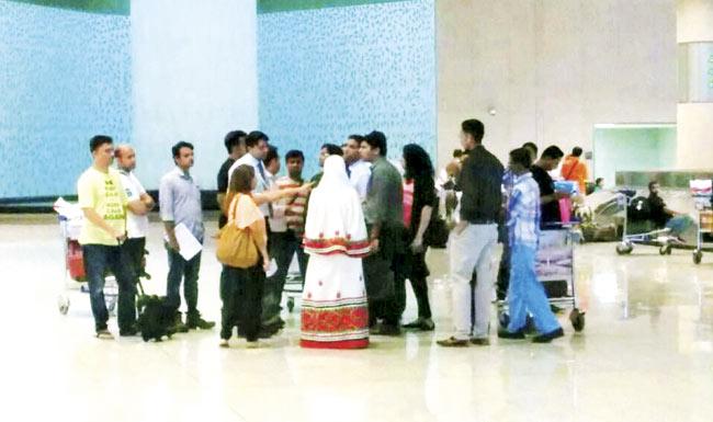 Angry passengers at Terminal 2 confront a couple of SpiceJet officials about their missing luggage
