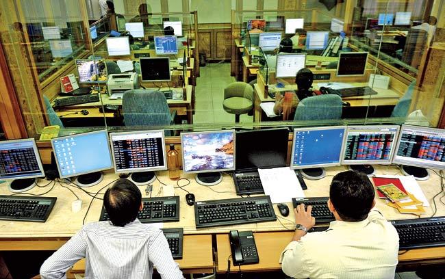 Stockbrokers monitor share prices on the National Stock Exchange (NSE) terminal at a brokerage firm in Mumbai