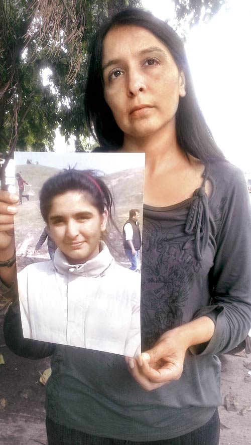 Sukhdeep Kaur holds up a photo of her daughter Gunreet Kaur (18)