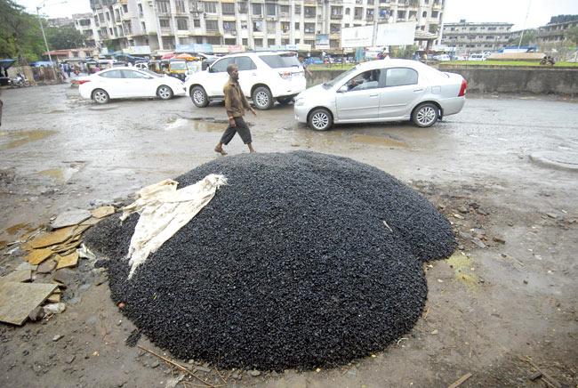 Tar and stone crush has been brought in to repair the huge potholes. Pics/Sameer Markande