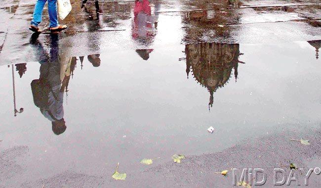 Reflections: A fun way to look at the city during the monsoon is to peep into water-logged potholes and see an almost perfect reflection of Mumbai. Pic/Atul Kamble