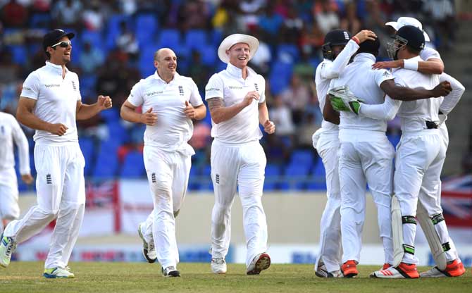 English players celebrate after Chris Jordan (3rd R) caught Kraigg Brathwaite for 39 runs off the bowling of James Tredwell (2nd L) on day two of the first test match between West Indies and England at the Sir Vivian Richard Stadium in St John
