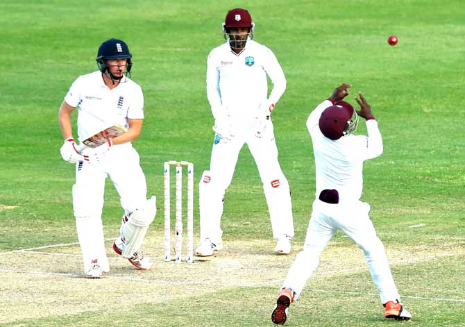 English batsman Gary Ballance (L) watches as West Indies fielder Jermaine Blackwood (R) fails to take a catch on day three of the first test match between West Indies and England at the Sir Vivian Richard Stadium in St John