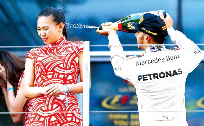 Lewis Hamilton sprays champagne at Liu Siying at the podium after winning the Chinese Grand Prix last Sunday. Pic/Getty Images