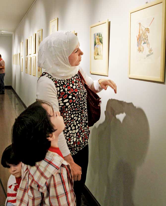 A Syrian mother and her children look at printed artwork of artist Salvador Dali at a gallery in Damascus on May 12, 2010. Pic/AFP