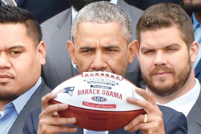 Barack Obama holds a football presented to him by NFL champs New England Patriots at the White House in Washington DC. PIC/AFP 