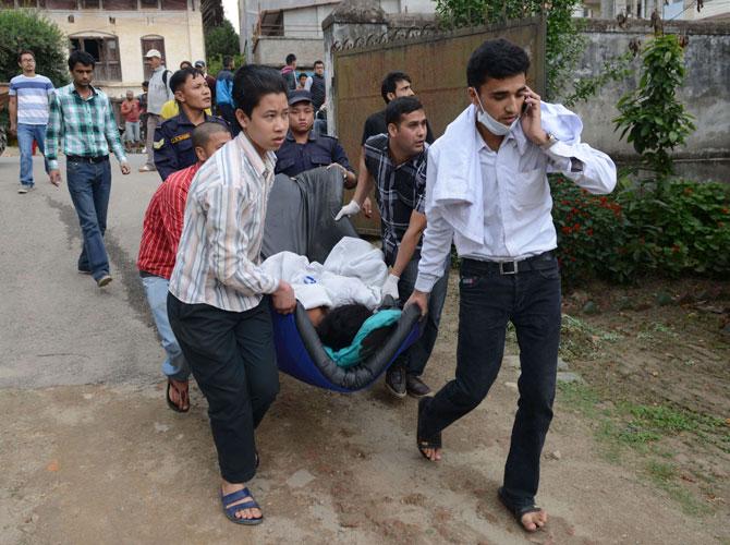 Health workers carry injured people into an open area following an 7.9 earthquake, at Lalitpur on the outskirts of Kathmandu. Pic AFP