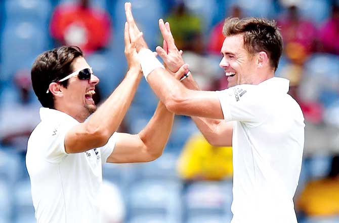 England skipper Alastair Cook (left) celebrates with pace ace James Anderson after West Indies batsman Jason Holder was run out on the final day of the second Test at Grenada National Cricket Stadium on Saturday. Pic/AFP 