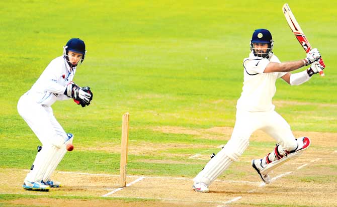 Cheteshwar Pujara cuts his way to 81 against Derbyshire, watched by wicketkeeper Harvey Hosein on July 2, 2014. Pic/Getty Images