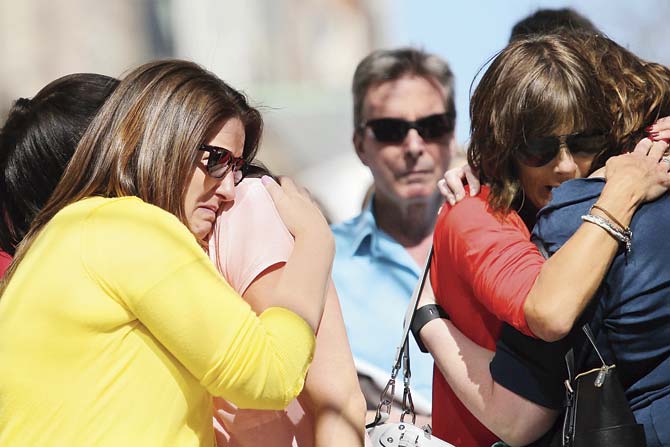 (L-R) Jenna Dziedzic of Boston, MA, Sabrina Dellorusso of Boston, MA, Linda Witt of Neenah, WI, and Jillian Boynton of Manchester, NH, react during a moment of silence at 2:49 p.m. ET near the finish line of the Boston Marathon on Boylston Street, commemorating the two-year anniversary of the 2013 Boston Marathon bombings, on April 15, 2015 in Boston, Massachusetts. Pic/Getty Images/AFP