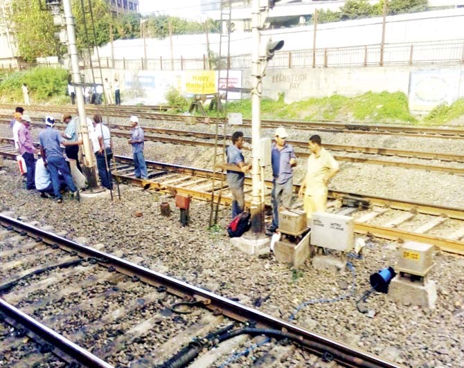 Workers trying to fix the signalling system that went awry after a thief stole all the 28 cables inside a junction box at Lower Parel