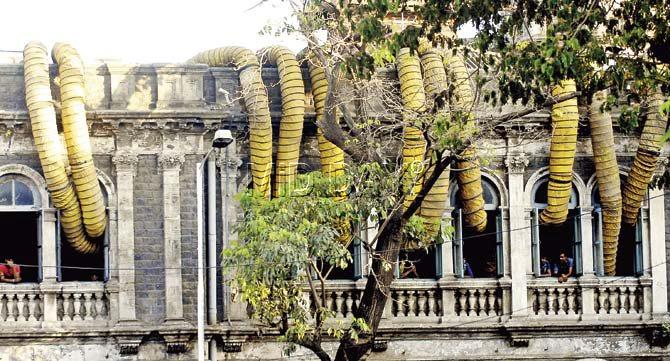 Along with the roots of banyan and peepal trees, air-conditioning ducts too find their place on the Capitol theatre building. Pic/Suresh KK