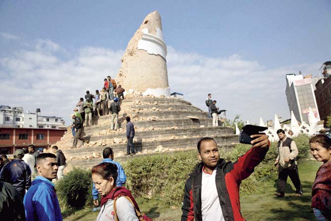 A man clicks a selfie in front of what used to be the Dharahara tower in Kathmandu. Pic/PTI