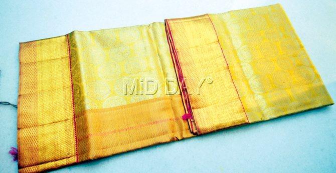An off-white Kanjivaram sari in multiple weaves; it has motifs of elephants and horses 