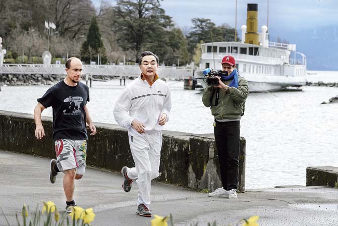 Chinese Foreign Minister Wang Yi (centre) jogs along Lake Geneva during the Iran nuclear talks. China views Iran as a strong West Asian power and a suitable candidate for Chinese friendship in the context of US hostility. Regardless of what happens with the nuclear deal, China is not expected to revert to the previous scale of sanctions and will continue to strengthen its military ties. Pic/AFP