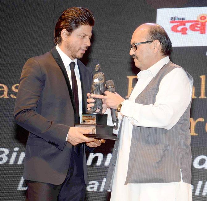 Shah Rukh Khan receives the award from politician Amar Singh 