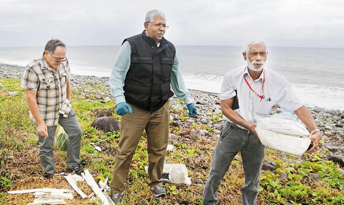 A team of experts look for debris from the ill-fated Malaysia Airlines flight MH370 on a beach in Saint-Andre de la Reunion