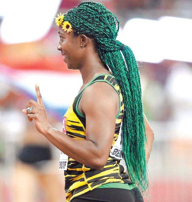 Fraser-Pryce competed wearing a band of yellow flowers in her green-dyed hair. Pic/AFP