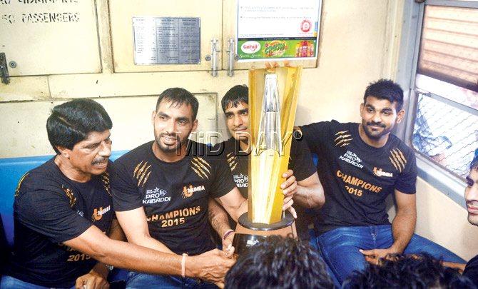 U Mumba team captain Anup Kumar (second from left) with teammates hold their Pro Kabaddi League-2 trophy during a train journey from Andheri to Churchgate as part of their victory parade yesterday. Pics/Pradeep Dhivar