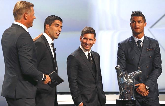 FC Barcelone Argentinian striker Lionel Messi (2ndR) shares a laugh with his Urugayan teammate Luis Suarez (2ndL) and Danish former football player and ceremony host Peter Schmeichel (L) eyed by Real Madrid